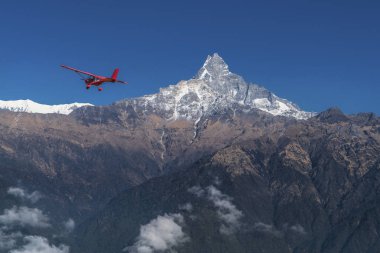 Ultralight plane flies over Pokhara and Machapuchare in Annapurna region, Nepal clipart