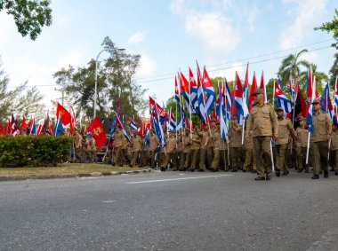 Havana'da Mayıs gündüz bayraklarıyla yürüyen insanlar