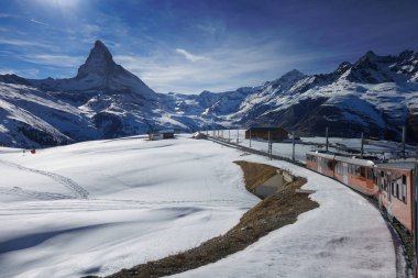 Kışın kayak merkezi Zermatt, Kanton Valais, İsviçre yüksek Matterhorn dağ manzaralı karda Gornergrat demiryolu kırmızı Tren