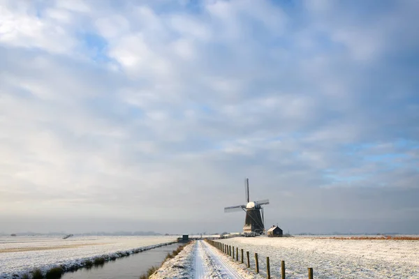 Windmolen in de sneeuw in een nederlands minimalistisch landschap Stockfoto