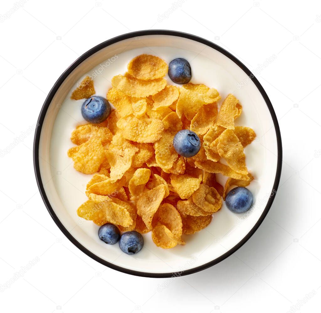 bowl of cornflakes and milk decorated with blueberries isolated on white background, top view