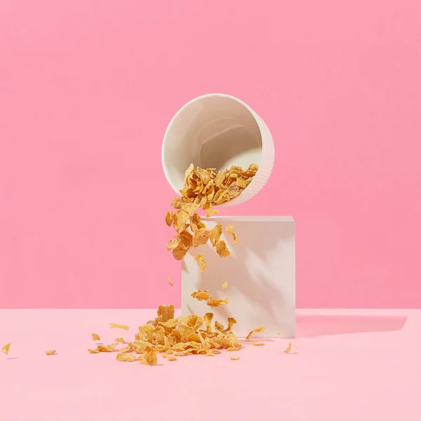 Кукурудзяні Пластівці Випадають Білої Миски Рожевому Фоні — стокове фото