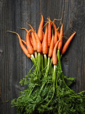 Kırsal mutfak masasında taze çiğ havuç, üst manzara.