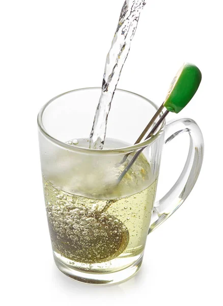 沸かしたお湯をお茶のカップに注ぎ 白い背景に隔離された緑茶を作る — ストック写真