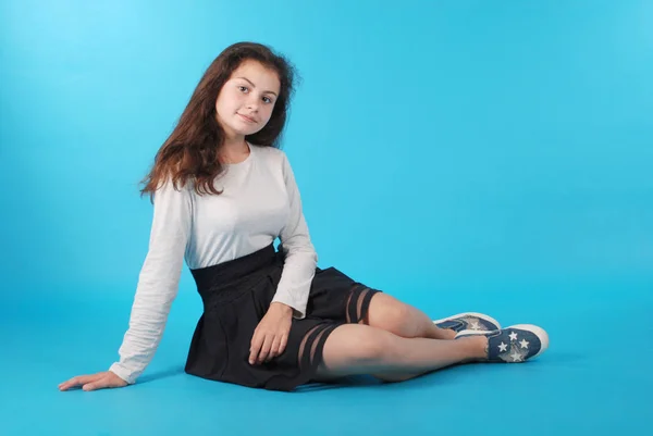 Jeune Fille Assise Sur Sol Sur Fond Bleu Studio — Photo