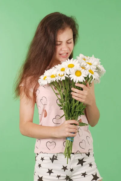 工作室肖像过敏性黑发年轻女孩 对花卉过敏反应 选择性重点 在绿色背景上隔离 — 图库照片