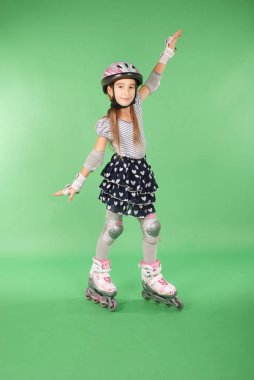 Yeşil arka planı izole rollerskates güzel kız