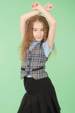 Güzel genç kız okul üniforması üzerinde yeşil arka plan izole