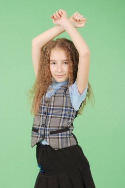 Güzel genç kız okul üniforması üzerinde yeşil arka plan izole
