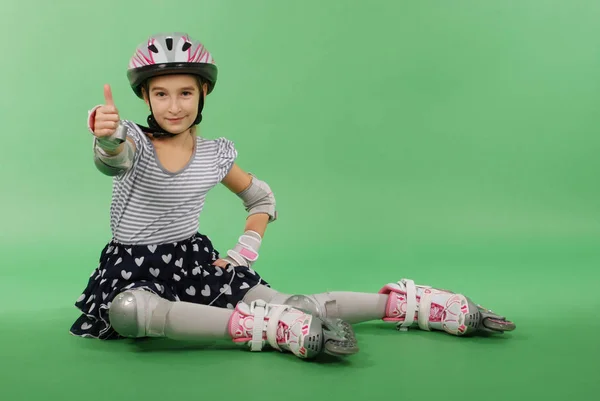 Hübsches Mädchen Mit Rollschuhen Auf Grünem Hintergrund Liegend — Stockfoto