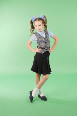 Güzel genç kız okul üniforması üzerinde yeşil arka plan izole