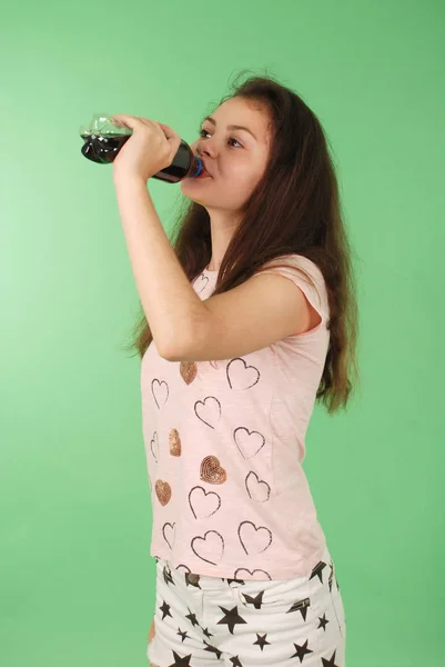Красивая Молодая Девушка Держит Руках Колу Бутылке Изолированы Зеленом Фоне — стоковое фото