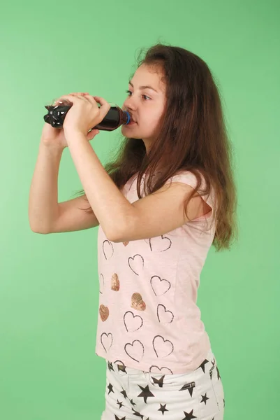 Piękna Młoda Dziewczyna Trzymając Rękach Cola Butelce Białym Tle Zielonym — Zdjęcie stockowe