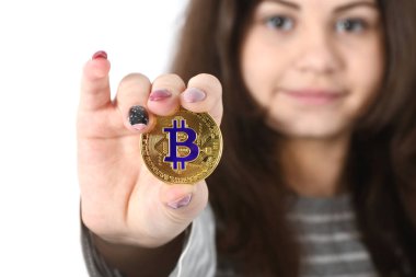 Güzel kız onun önünde tutan yeni altın cryptocurrency bitcoin beyaz arka plan üzerinde eller. Yumuşak odak