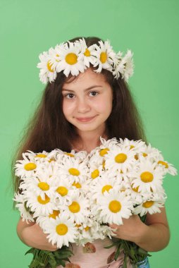 Yeşil arka plan üzerinde papatya çelenk ile güzel kız. 