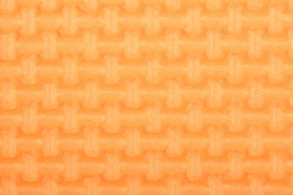 Struttura di una stuoia di palestra di lucentezza arancione di polietilene. Tessitura tappetino yoga . — Foto Stock