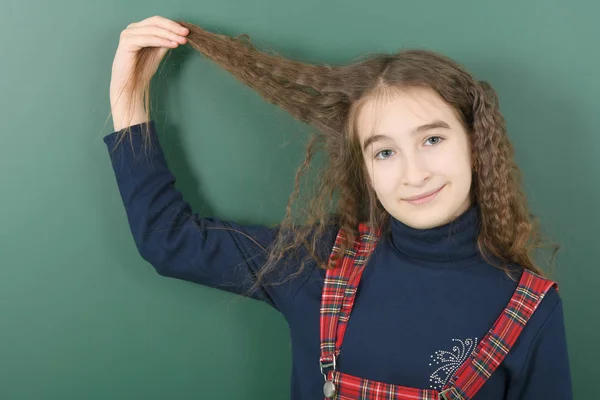 Schoolgirl near green school board. — Stock Photo, Image