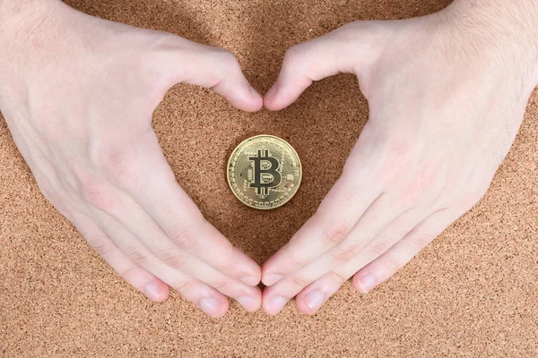 Manos sostiene y muestra el corazón nuevo bitcoin criptomoneda de oro — Foto de Stock