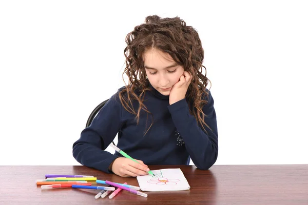 Fiatal iskoláslány felhívja markerek, miközben ül az asztalnál — Stock Fotó
