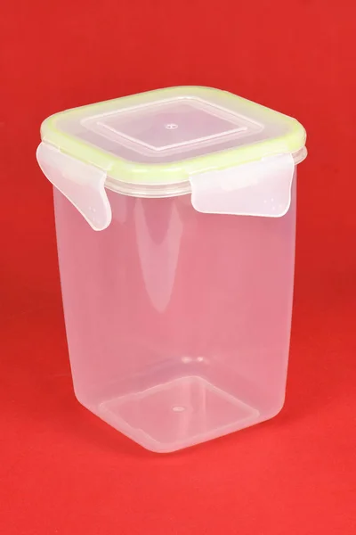 Boîte en plastique alimentaire isolée sur rouge . — Photo