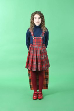 Yeşil arka planda yalıtılmış kırmızı bir paket olan çocuk. Küçük güzellik alışverişkolik. Tatil hediyesi, alışveriş. 