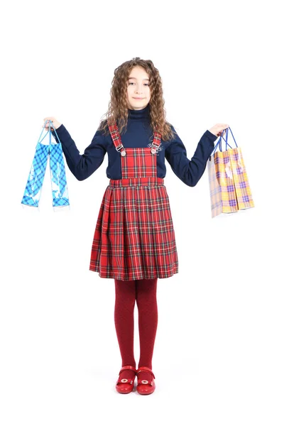 Criança com uma embalagem de textura quadriculada isolada sobre fundo branco. A menina gosta de fazer compras na temporada de venda. Presente de férias, compras . — Fotografia de Stock