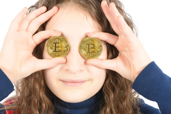 Chica feliz con el pelo rizado largo mantiene el ojo en lugar de dos bitcoin criptomoneda de plata en las manos sobre fondo blanco . — Foto de Stock