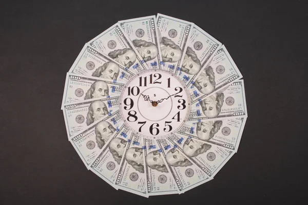 Η έννοια του ρολογιού και του δολαρίου. Ρολόι στο Καλειδοσκόπιο μάνταλα από χρήματα. Αφηρημένα χρήματα φόντο πλέγμα μοτίβο επαναλαμβάνεται κύκλος μάνταλα. — Φωτογραφία Αρχείου