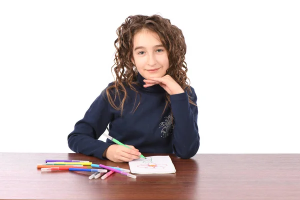 Fiatal iskoláslány felhívja markerek, miközben ül az asztalnál — Stock Fotó