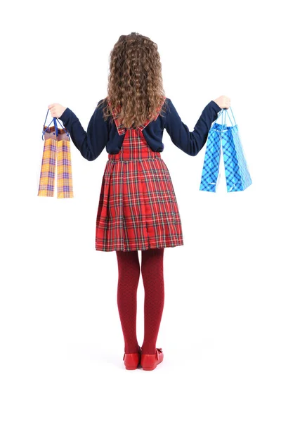 Criança com uma embalagem de textura quadriculada isolada sobre fundo branco. A menina gosta de fazer compras na temporada de venda. Presente de férias, compras . — Fotografia de Stock