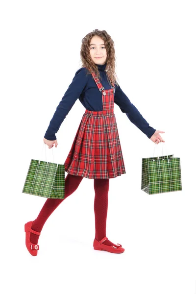 Niño con una textura a cuadros de embalaje verde aislado sobre fondo blanco. Chica le gusta ir de compras en temporada de venta. Regalo de vacaciones, compras . — Foto de Stock