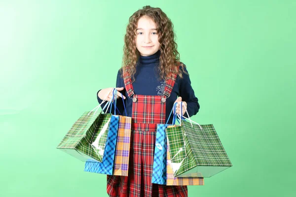 Criança com uma embalagem de textura quadriculada isolada sobre fundo branco. A menina gosta de fazer compras na temporada de venda. Presente de férias, compras . — Fotografia de Stock