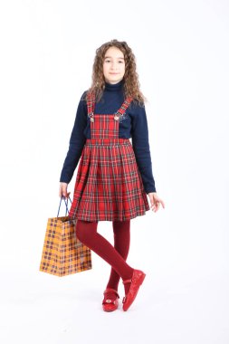 Beyaz arka planda izole edilmiş sarı ambalajlı damalı bir dokuya sahip çocuk. Tatil hediyesi, alışveriş. 