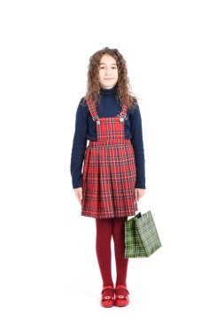 Beyaz arka planda izole edilmiş yeşil ambalajlı damalı bir dokuya sahip çocuk. Kız satış sezonunda alışveriş seviyor. Tatil hediyesi, alışveriş. 