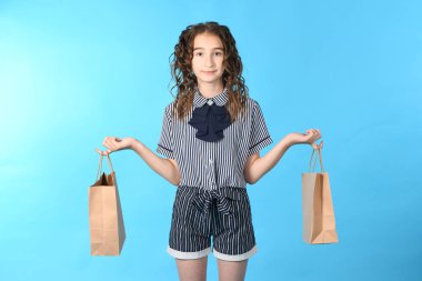 Mavi arka planda izole edilmiş bir paketolan çocuk. Tatil hediyesi, alışveriş. Alışveriş merkezinde çocuk mutlu alışveriş. 