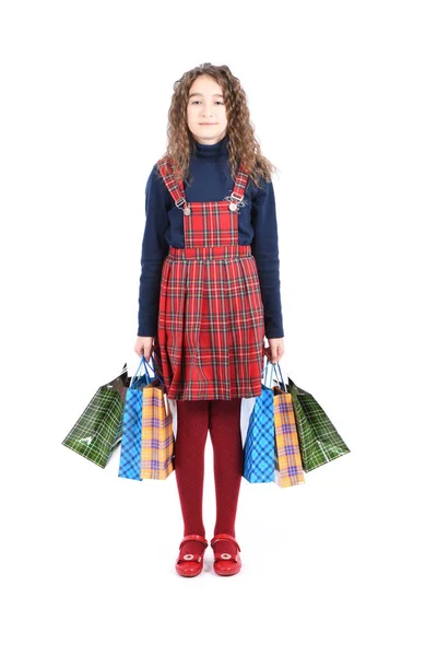 Kind met een gecheckerde textuur, geïsoleerd op een witte achtergrond. Meisje houdt van winkelen op verkoopseizoen. Vakantie aanwezig, winkelen. — Stockfoto