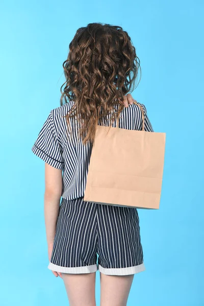 Bambino con un pacchetto isolato su sfondo blu. Regalo di festa, shopping. Ragazzo felice shopping nel centro commerciale . — Foto Stock