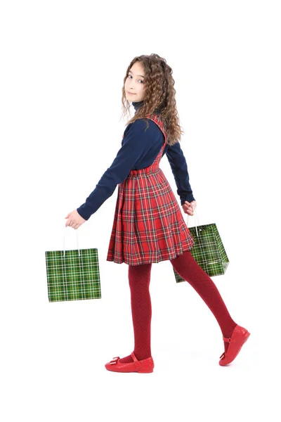 Criança com uma textura quadriculada de embalagem verde isolada sobre fundo branco. A menina gosta de fazer compras na temporada de venda. Presente de férias, compras . — Fotografia de Stock