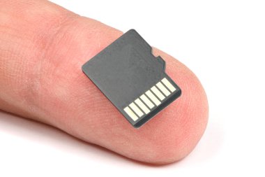 Parmak üzerindeki hafıza kartı beyaz arkaplanda izole edilmiş. Yüksek çözünürlüklü. Tam alan derinliği.