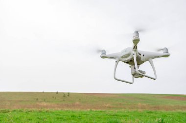 yeşil alanın üzerine mavi gökyüzünde uçan quadcopter dron