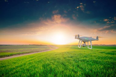 yeşil alanın üzerine mavi gökyüzünde uçan quadcopter dron