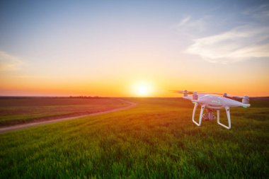 yeşil alanın üzerine mavi gökyüzünde uçan quadcopter dron