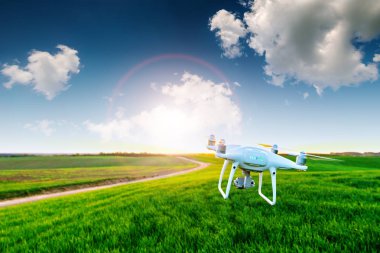 yeşil alanın üzerine mavi gökyüzünde uçan quadcopter dron