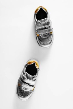 düz yatıyordu, gümüş çocuk spor ayakkabı beyaz bir arka plan üzerinde izole