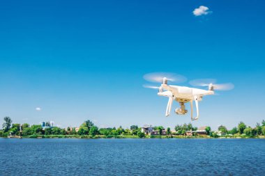 plaj üzerinde mavi gökyüzünde uçan quadcopter dron