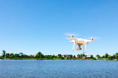 plaj üzerinde mavi gökyüzünde uçan quadcopter dron