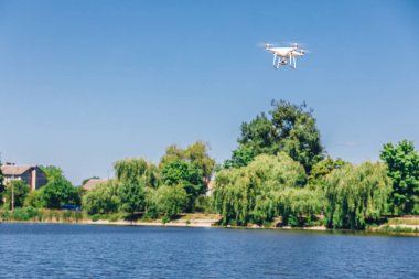 plaj üzerinde mavi gökyüzünde uçan quadcopter dron