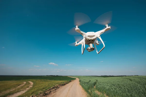 Quadcopter Drone Voando Céu Azul Sobre Campo Verde — Fotografia de Stock