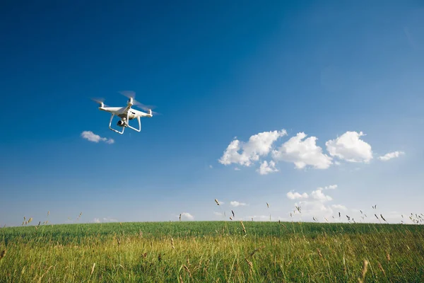 Quadcopter Drone Voando Céu Azul Sobre Campo Verde — Fotografia de Stock