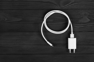 Ahşap arka planda kablo telefon şarj cihazları